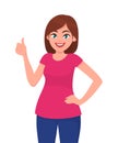 Young woman showing thumps up sign or gesture.Young woman showing thumps up sign or gesture while holding hand on hip. Royalty Free Stock Photo