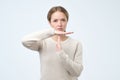 Young woman showing time out gesture with hands isolated on gray wall background. Negative human emotion Royalty Free Stock Photo