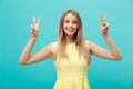 Young woman showing two fingers, positive or peace gesture, on white. Royalty Free Stock Photo