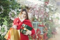 Young woman shows her gift packs inside a Christmas shop