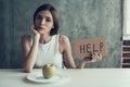 Young Woman with Sign Help and Eating One Apple.