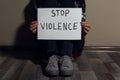 Young woman with sign STOP VIOLENCE near wall, closeup Royalty Free Stock Photo