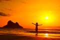 Young woman silhouette on the beach in summer sunset lght