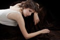 Young woman in silk blouse reclines on velvet Royalty Free Stock Photo