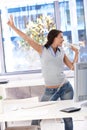 Young woman singing in bright office