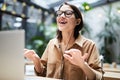 Young woman singing favorite song at workplace