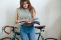 Young woman sipping coffee or tea and reading magazine Royalty Free Stock Photo