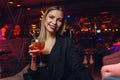 Young woman sipping red sweet drink in bar. Royalty Free Stock Photo