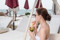 Young Woman Sipping Tropical Drink on Resort Patio Royalty Free Stock Photo