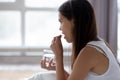 Young woman sit in bed talking pill drinking water Royalty Free Stock Photo