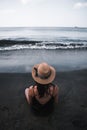 Young woman sit in the black sand beach Royalty Free Stock Photo