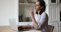 Young woman working on laptop feels tired takes off glasses