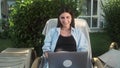 Young woman sit in park communicating by video call. Girl speaking looking at laptop computer, online conference