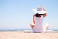 Young woman sits on the beach