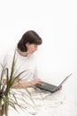 Young woman sits in bed with laptop and works. Freelancer. Remote work. Work during sick leave Royalty Free Stock Photo