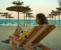 Young woman sits in a chair by the sea, Varna, Bulgaria Royalty Free Stock Photo