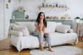 Young Woman sits on Couch at Home, Resting. Girl Props her chin up with her Hand Royalty Free Stock Photo