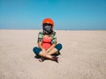 Young woman sits in the desert wearing a helmet for buggy.