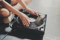 A young woman sits on the floor and explores vinyl records, puts them on a retro player Royalty Free Stock Photo