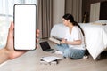 A young woman sits on the floor and reading a book. There are papers and a laptop on the floor. A close-up hand holding Royalty Free Stock Photo