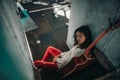 A young woman sits with guitar inside of old abandoned ship Royalty Free Stock Photo