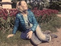 Young woman sits near the bright blossoming tulips , toning, retro effect