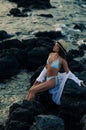 Young woman sits on rock near sea Royalty Free Stock Photo