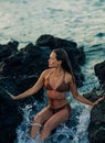 Young woman sits on rock near sea Royalty Free Stock Photo