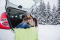 Young woman sits in the trunk of the car and holds a cup of hot tea Royalty Free Stock Photo