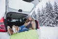 Young woman sits in the trunk of the car and holds a cup of hot tea Royalty Free Stock Photo