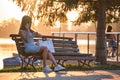 Young woman sitting alone on city street outdoors waiting for someone to arrive. Arriving late on business meeting Royalty Free Stock Photo