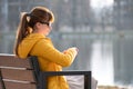 Young woman sitting alone on city street outdoors waiting for someone to arrive. Arriving late on business meeting