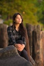 Young woman sitting along lake pier looking towards sunset Royalty Free Stock Photo