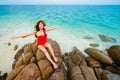 woman sitting with arms raised on stone beach with sea at Koh MunNork Island  Rayong  Thailand Royalty Free Stock Photo