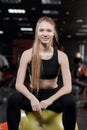 Young woman sitting with a ball in the gym Royalty Free Stock Photo