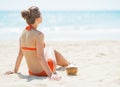 Young woman sitting on beach with coconut Royalty Free Stock Photo