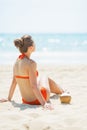 Young woman sitting on beach with coconut Royalty Free Stock Photo