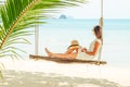 Young woman sitting on a beach swing Royalty Free Stock Photo