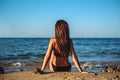 Young woman sitting on the beach and watching the sea Royalty Free Stock Photo