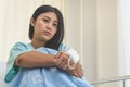 Young woman sitting on the bed and looking outside window in hospital worry about her illness Royalty Free Stock Photo