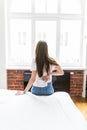 Young woman sitting on the bed with pain in neck wake up in the morning Royalty Free Stock Photo