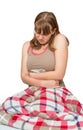 Young woman sitting on the bed with stomach pain Royalty Free Stock Photo