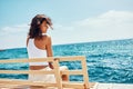 Woman sitting on a bench near the beach and enjoying in vacation Royalty Free Stock Photo