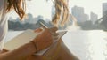 Young woman sitting on the bench in park and writing in diary, close-up