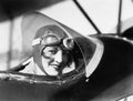 Young woman sitting in a biplane with hat and gargles