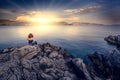 Young woman sitting by the blue mediterranean sea Royalty Free Stock Photo