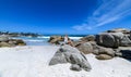 A young woman sittingon the boulders of clifton beach in the capetown area of south africa.