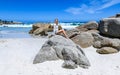 A young woman sittingon the boulders of clifton beach in the capetown area of south africa.2
