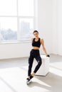 Young woman sitting on a box at gym after her workout. Female athlete taking rest after exercising at gym Royalty Free Stock Photo