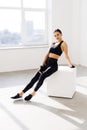 Young woman sitting on a box at gym after her workout. Female athlete taking rest after exercising at gym Royalty Free Stock Photo